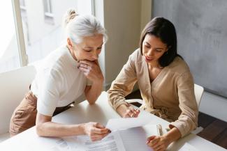 A young woman sitting with her mother and reviewing legal documents