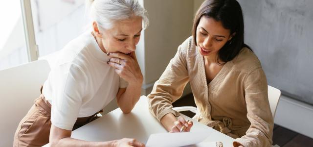 A young woman sitting with her mother and reviewing legal documents